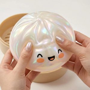 Squishy dumpling blanc cristal irisé tenu à deux mains - Planete Jouets France